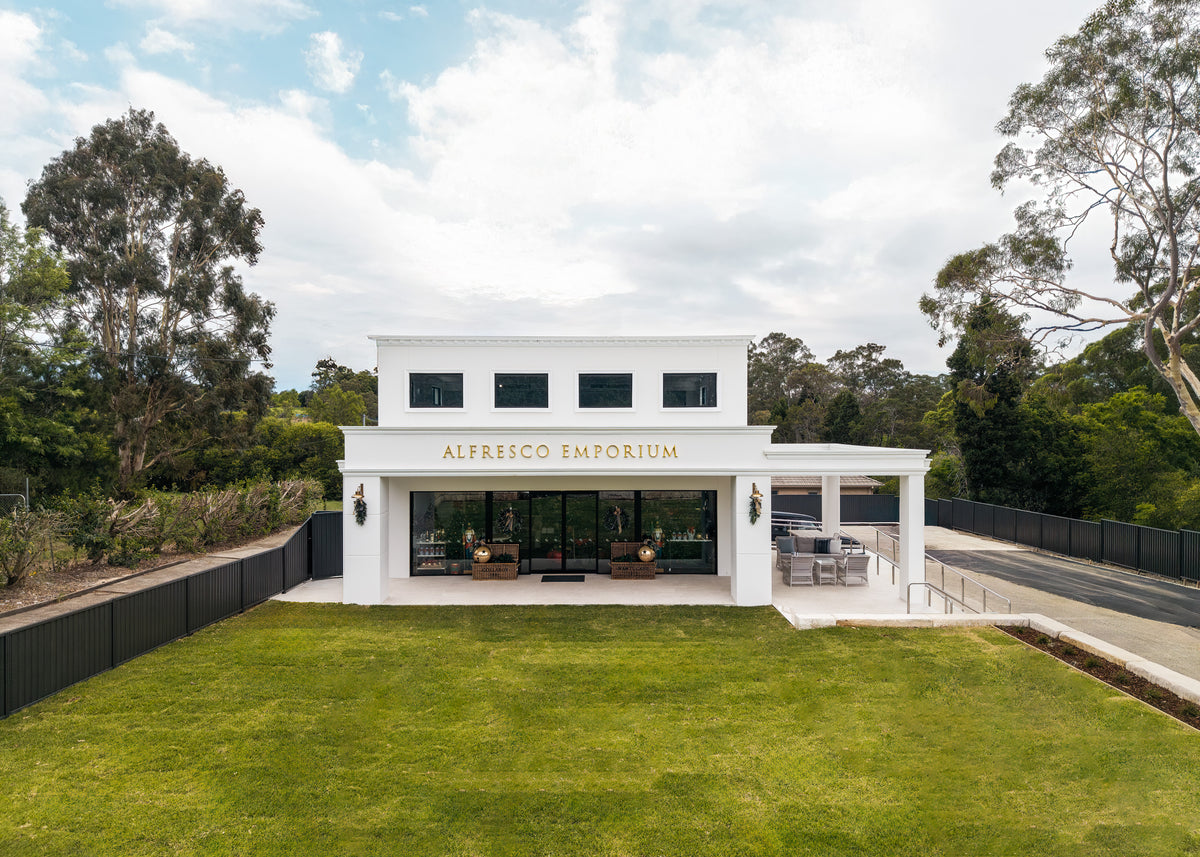 The outside of Alfresco Emporium Glenhaven - a white building surrounded by greenery.
