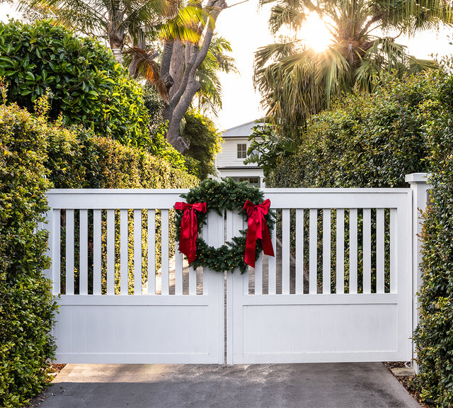 The split Christmas wreath hung on a white gate. Also perfect for double doors.