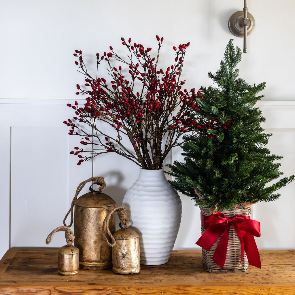 A small Christmas tree in a kubu basket on a side table.