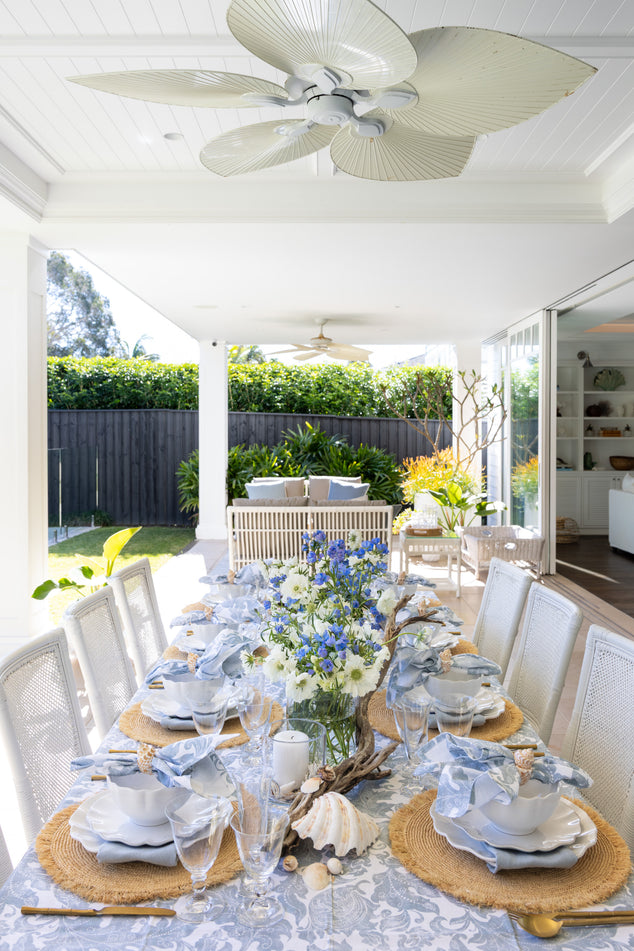 Outdoor Dining Setup with Flowers, Batik Tablecloth and Napkins, Shells, and Raffia Placemats