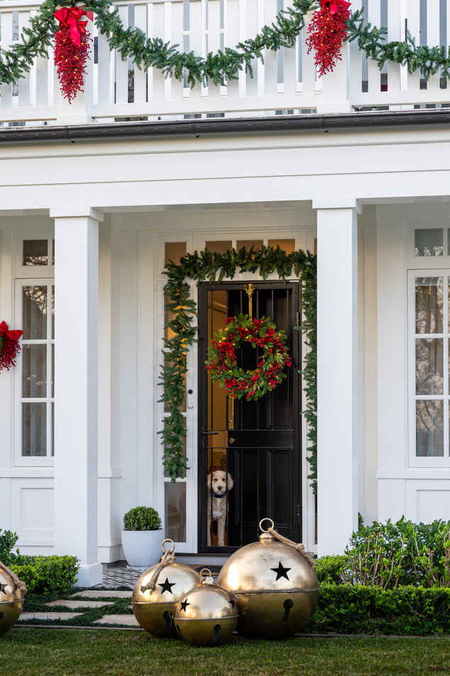 Front Door Styled with Christmas Wreath and Garland and Over sized Gold Bells in Front Lawn