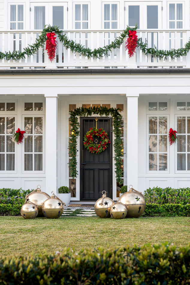 Decorative Christmas door with gold ornaments, wreaths, and garlands.