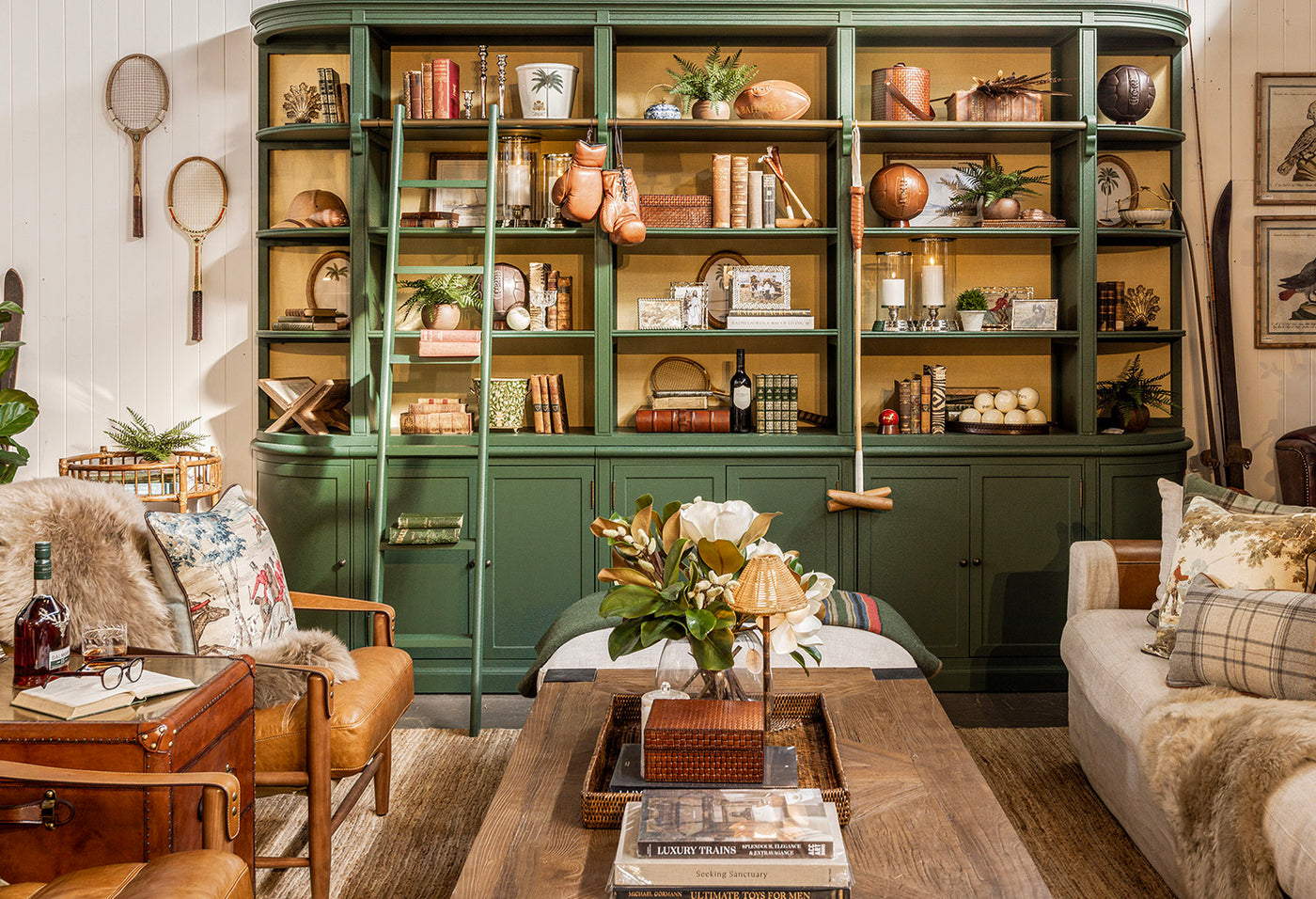 Living room with a large bookshelf filled with decorative items, a coffee table, and armchair.