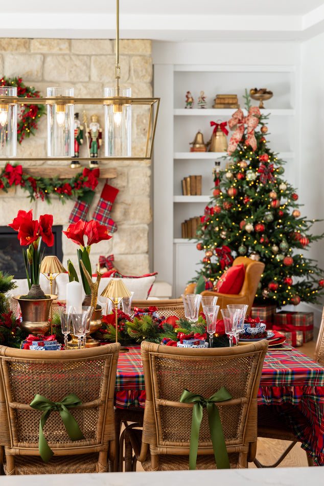 Decorated Christmas dining room with a tree, table, and chairs.
