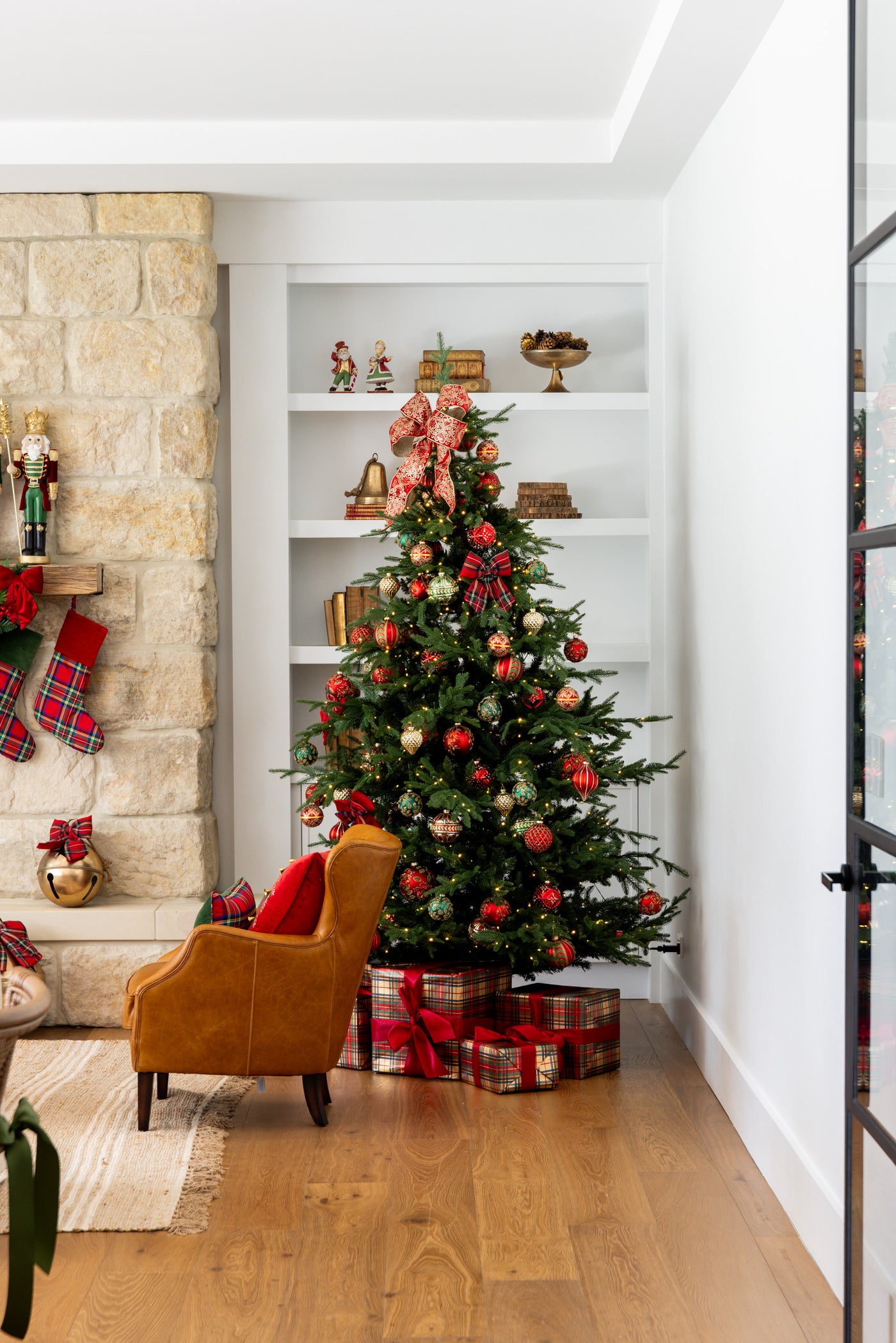 Vail Christmas Tree in Living Room Styled with Red and Green Baubles and topped with Red Velvet Bow