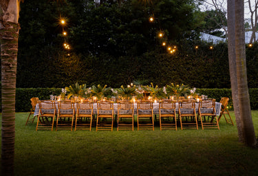 Island Dining Table Outside at Dusk with Festive lights and Palm Trees