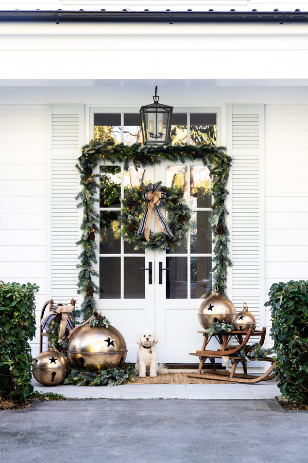 Front Door Styled with Hampton Blueberry Garland and Wreath with Dog out front with Oversized Gold Bells