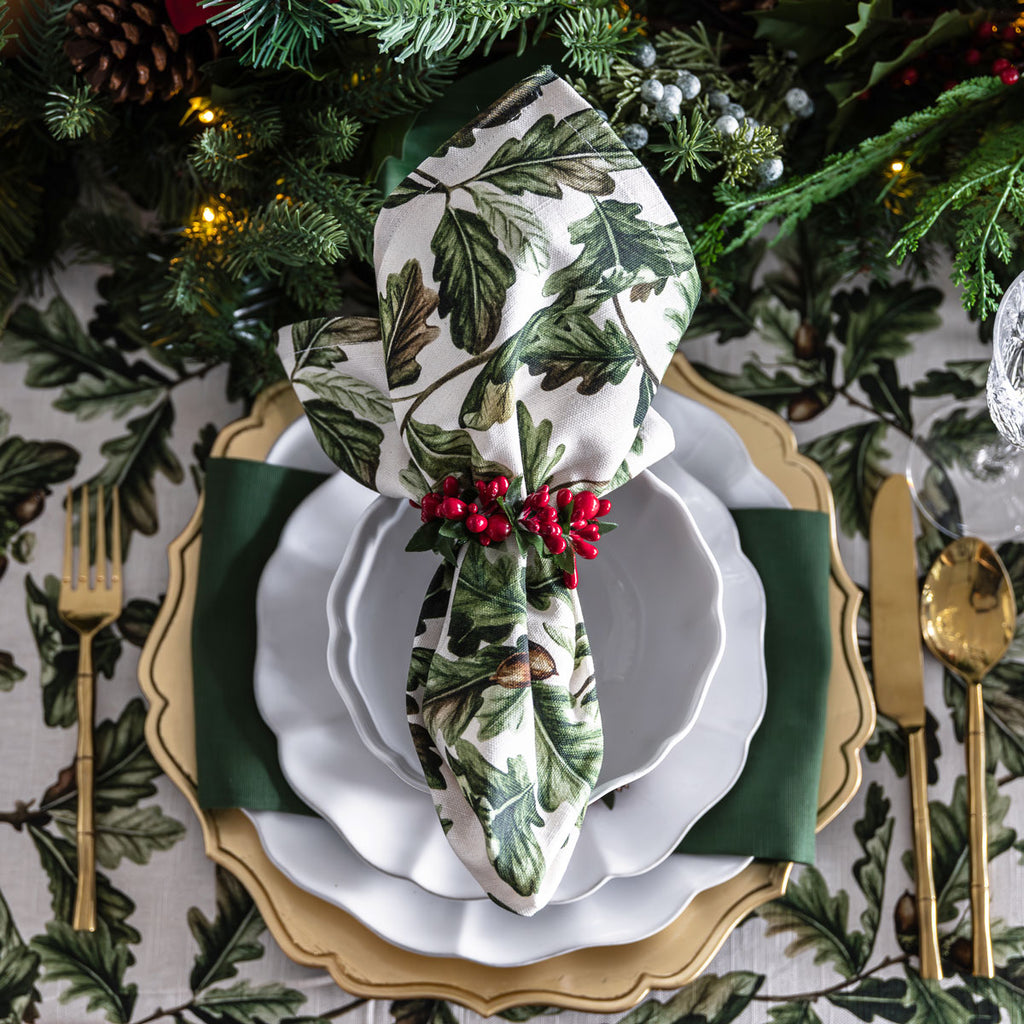 Green hemstitch napkin layered on Christmas table.