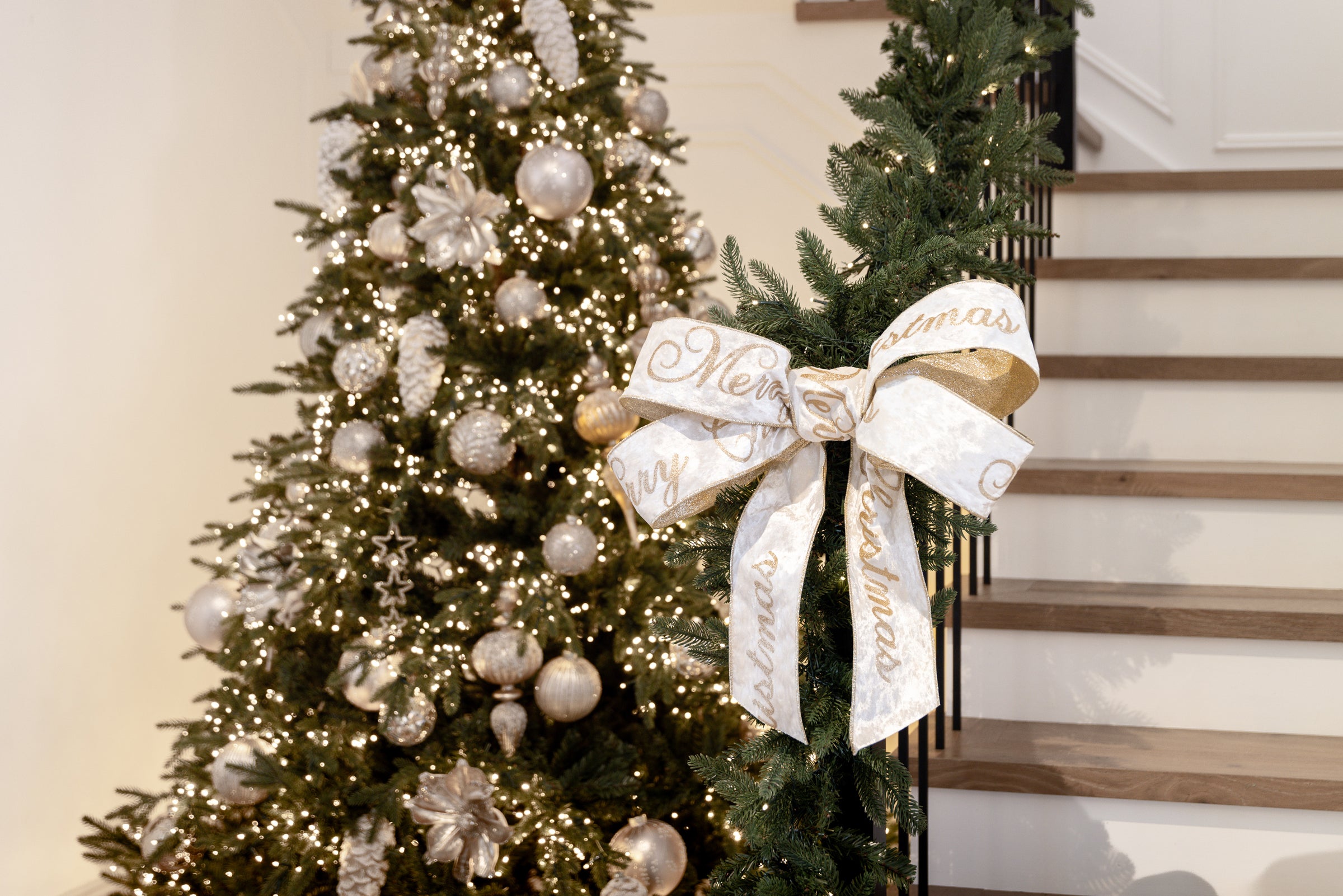 White Velvet Christmas Ribbon Tied in Bow on Staircase with Christmas Tree in the Background