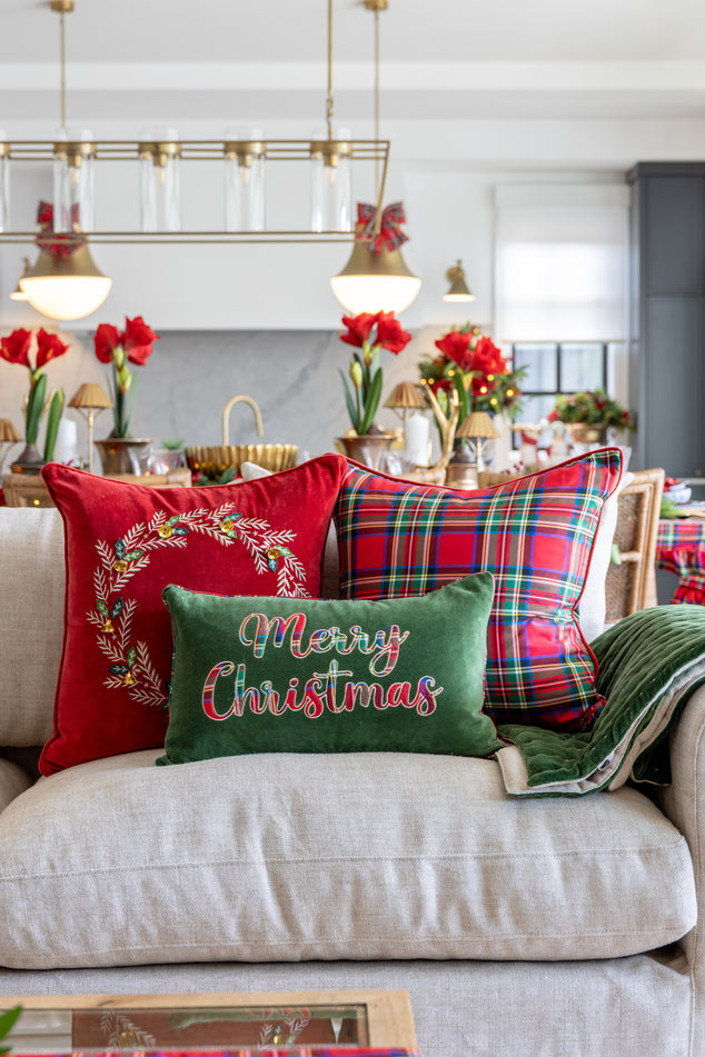 Christmas decorative cushions on a sofa with festive designs in a living room setting.
