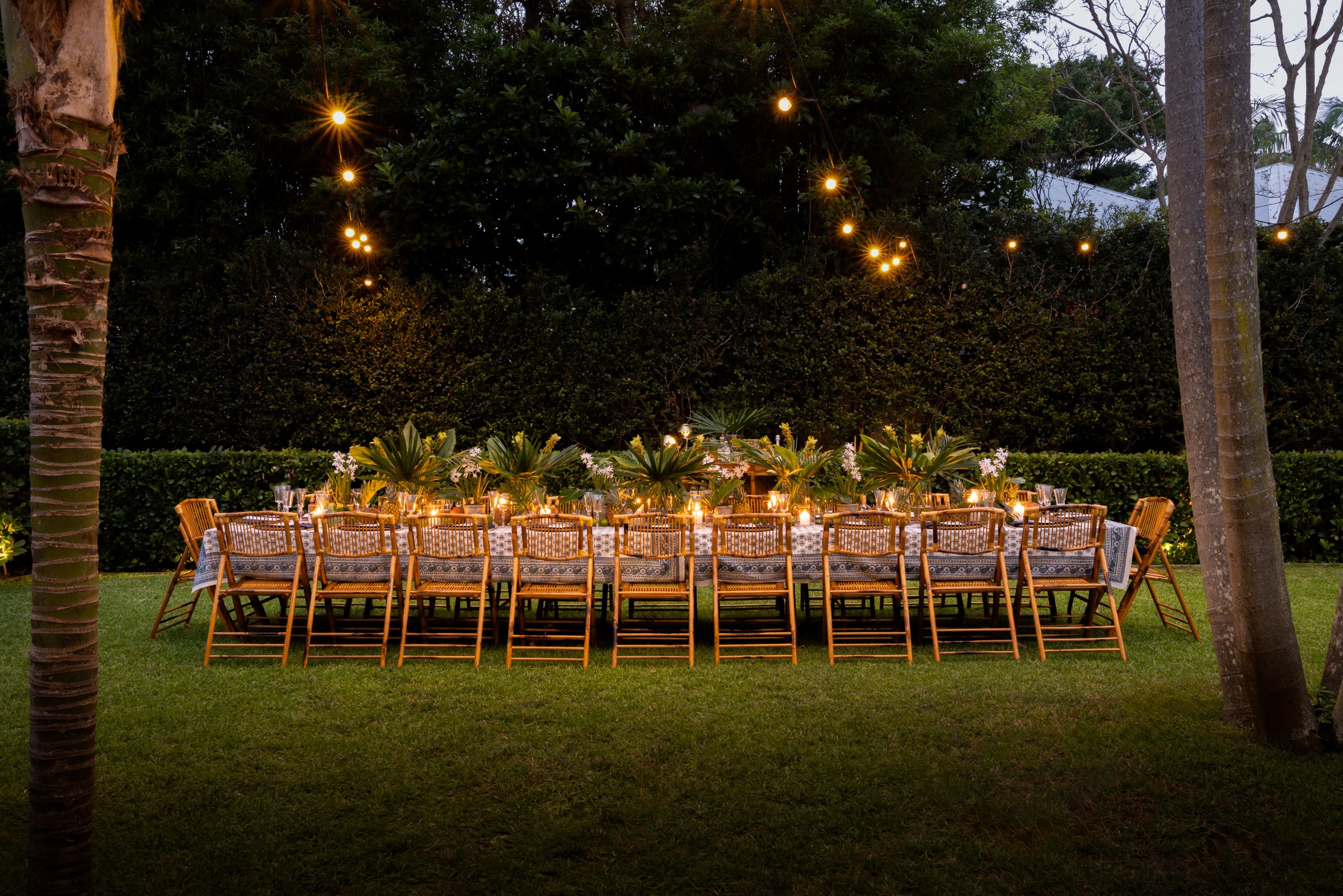 Island Dining Table Outside at Dusk with Festive lights and Palm Trees