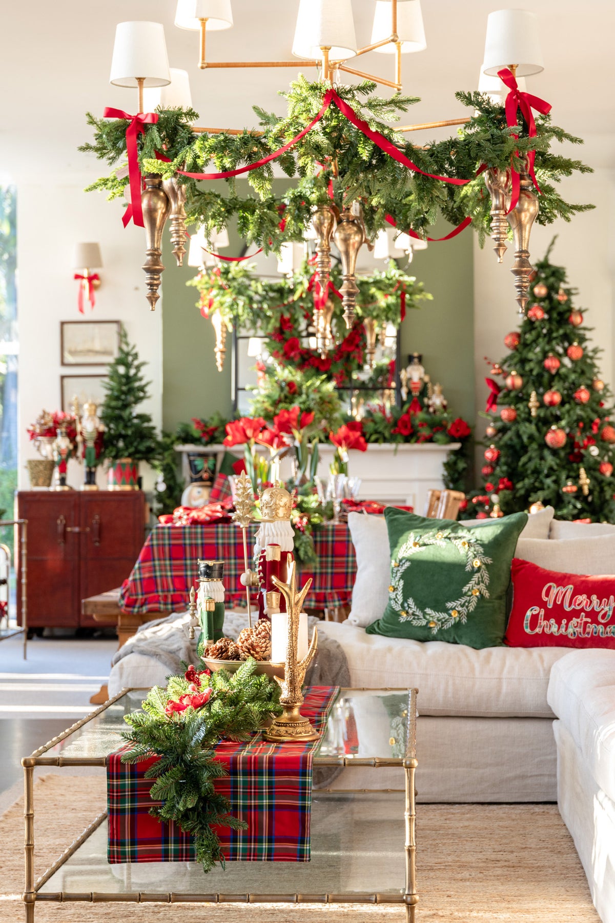 Decorated living room with Christmas trees, garlands, and festive decor.