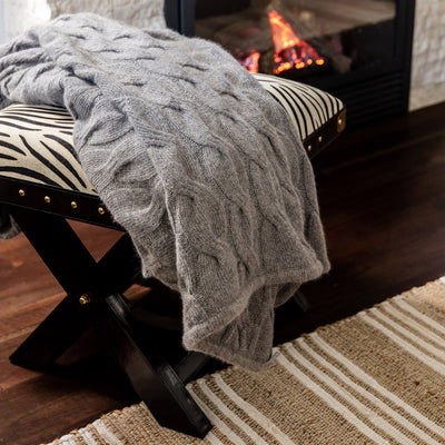 Bemboka Angora & Merino Chunky Cable Throw Mocha Styled on Zebra foot stool.