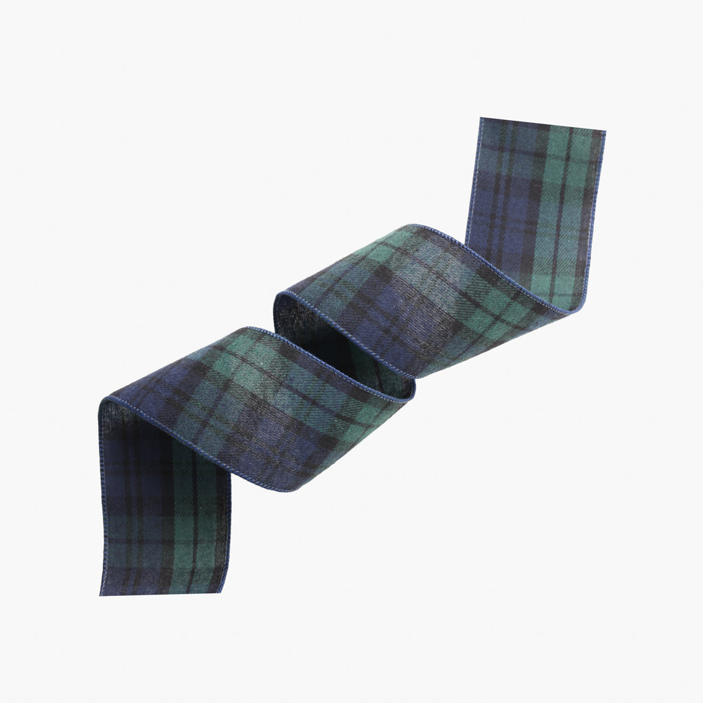 A rolled piece of tartan plaid fabric in green and blue, shown on a plain light gray background.