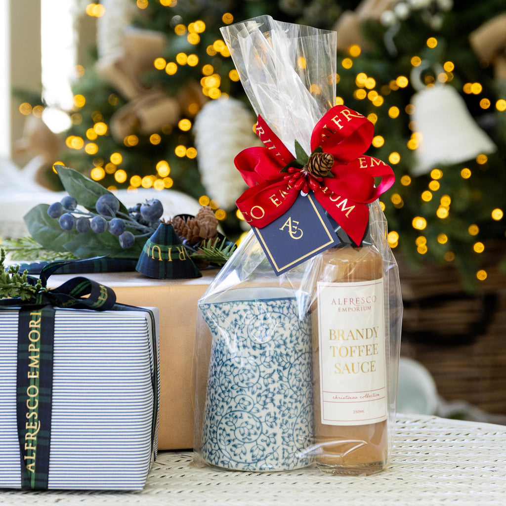 Brandy sauce and jug in front of a Christmas tree.