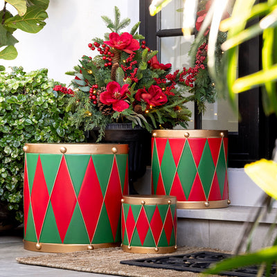 Red, green and gold Christmas drums near a front door.