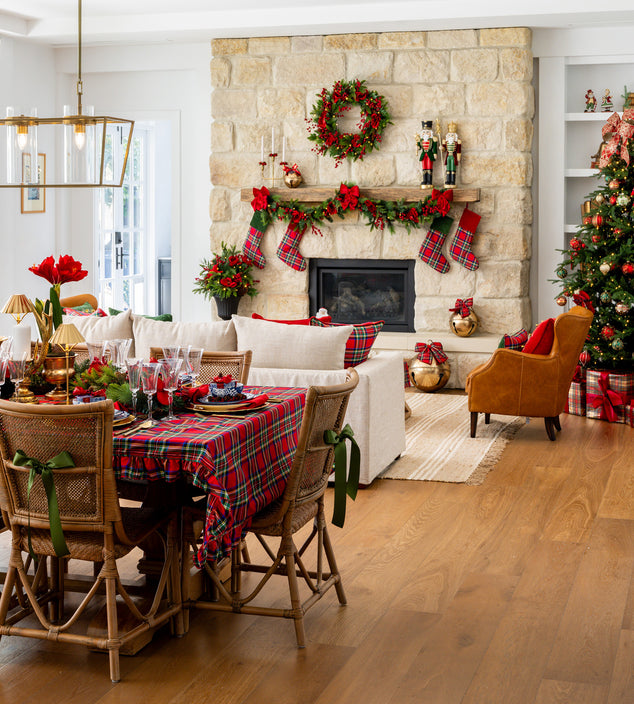 Tartan Christmas tablecloth in front of fireplace with wreath, stockings & nutcrackers.