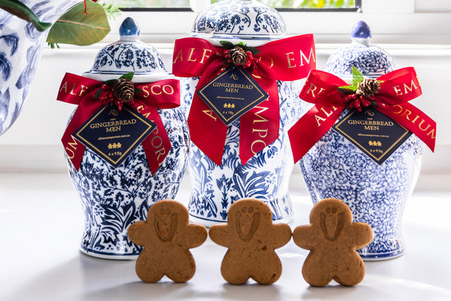 Blue and white jars with red bows filled with gingerbread men.