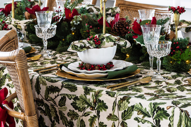 Oak leaf design tablecloth with gold bamboo cutlery and red berry Christmas accents.