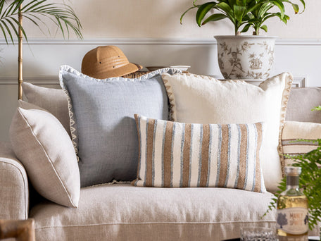 A trio of blue and white cushions on a latte lounge.