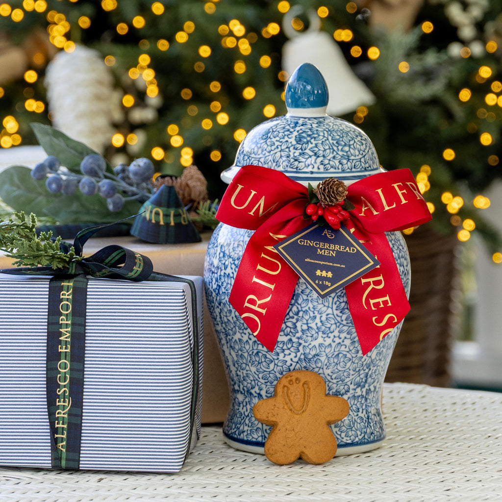 Dynasty Gingerbread Men Jar 2026 next to gifts with a gingerbread man in front.