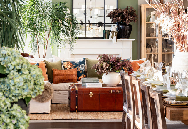 Leather trunk coffee table in a living room with floral navy cushions.