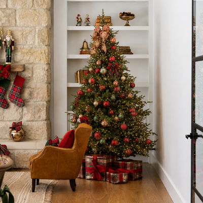 Decorated Christmas tree with ornaments and presents in a living room setting.