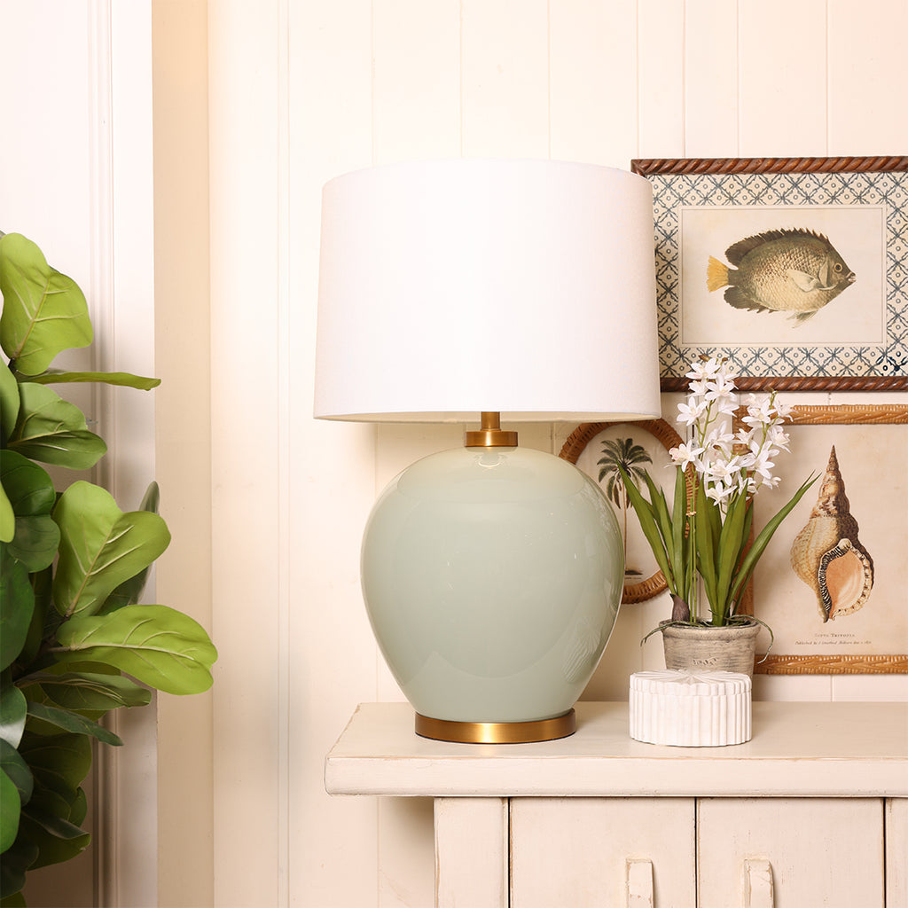 Green Glass Lamp with Shade Styled on Cabinet with Decor