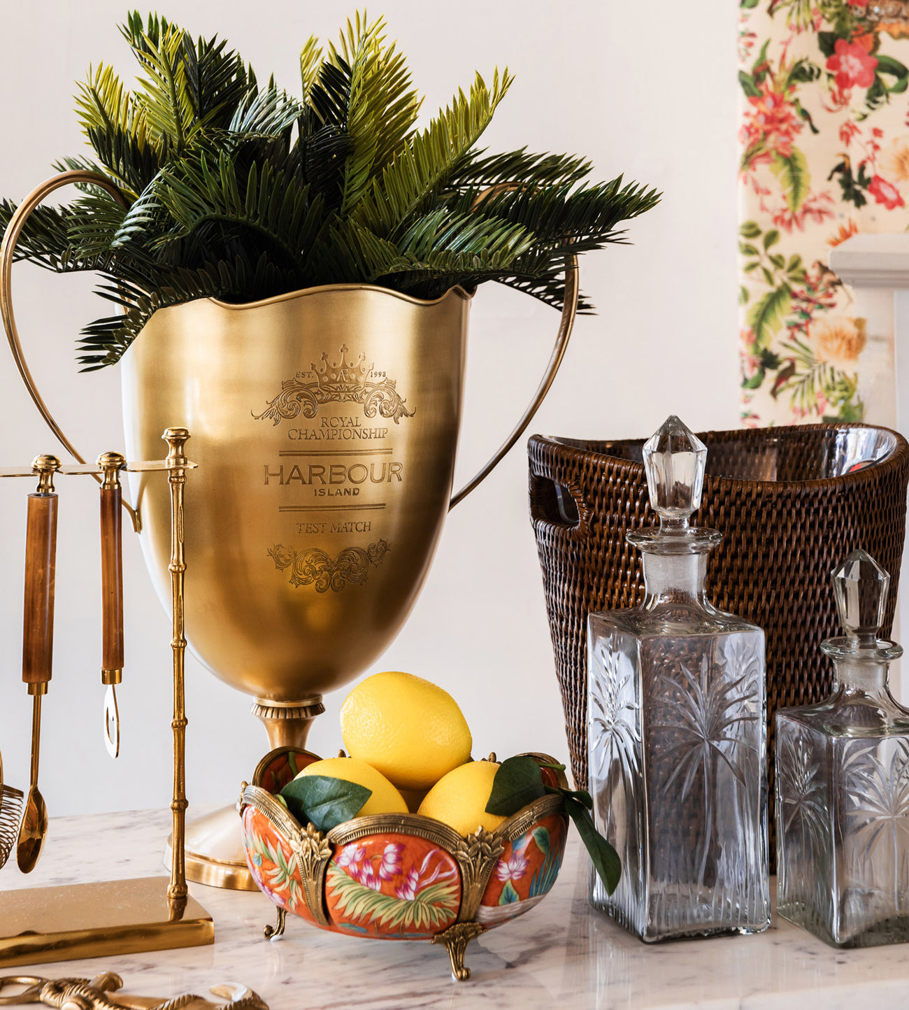 Close up of harbour island trophy with orange ceramic bowl and palm tree decanters.