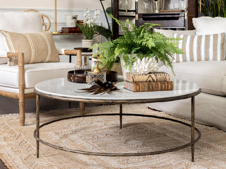 Marble and brass round coffee table in tropical style living room.
