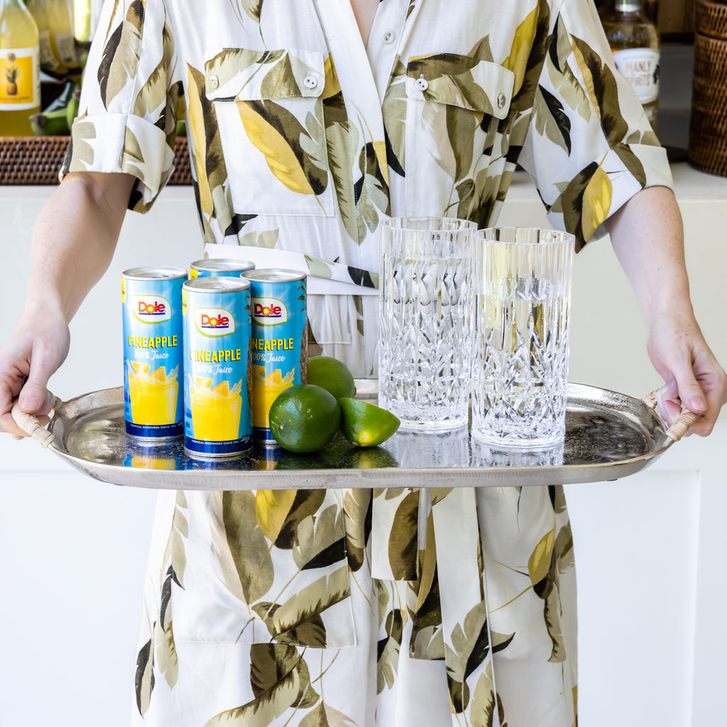 Metal Tray With Rattan Handles Styled with Limes, Glasses, and Juice