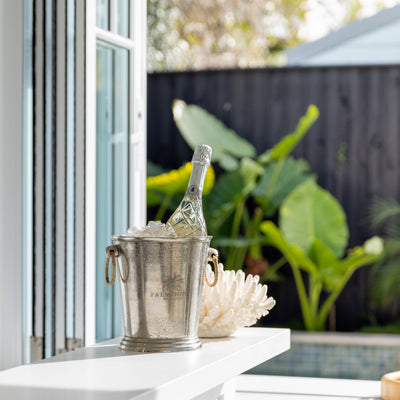 Palm House Metal Ice Bucket Styled on Bar Counter with Champagne