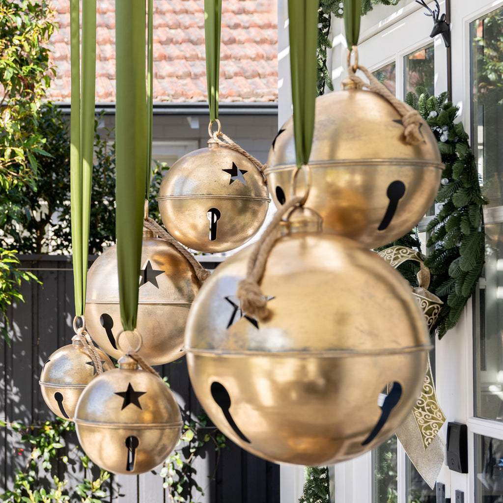 Gold bells with star designs hanging outdoors