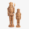 Two wooden nutcrackers with detailed armor and crowns on a white background