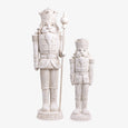 Two white nutcracker figurines on a white background