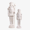 Two white nutcracker figurines on a white background