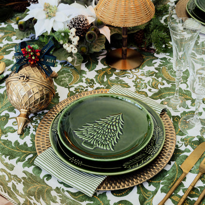 Pinecone & Christmas Tree Green Dinnerware styled on table with batik green tablecloth.