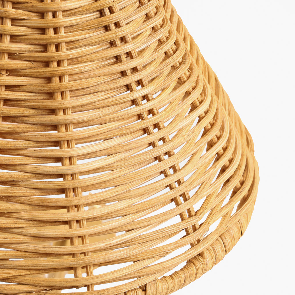 Close-up of a natural woven rattan or wicker basket with tight horizontal and vertical interlaced strands, shown against a plain white background.