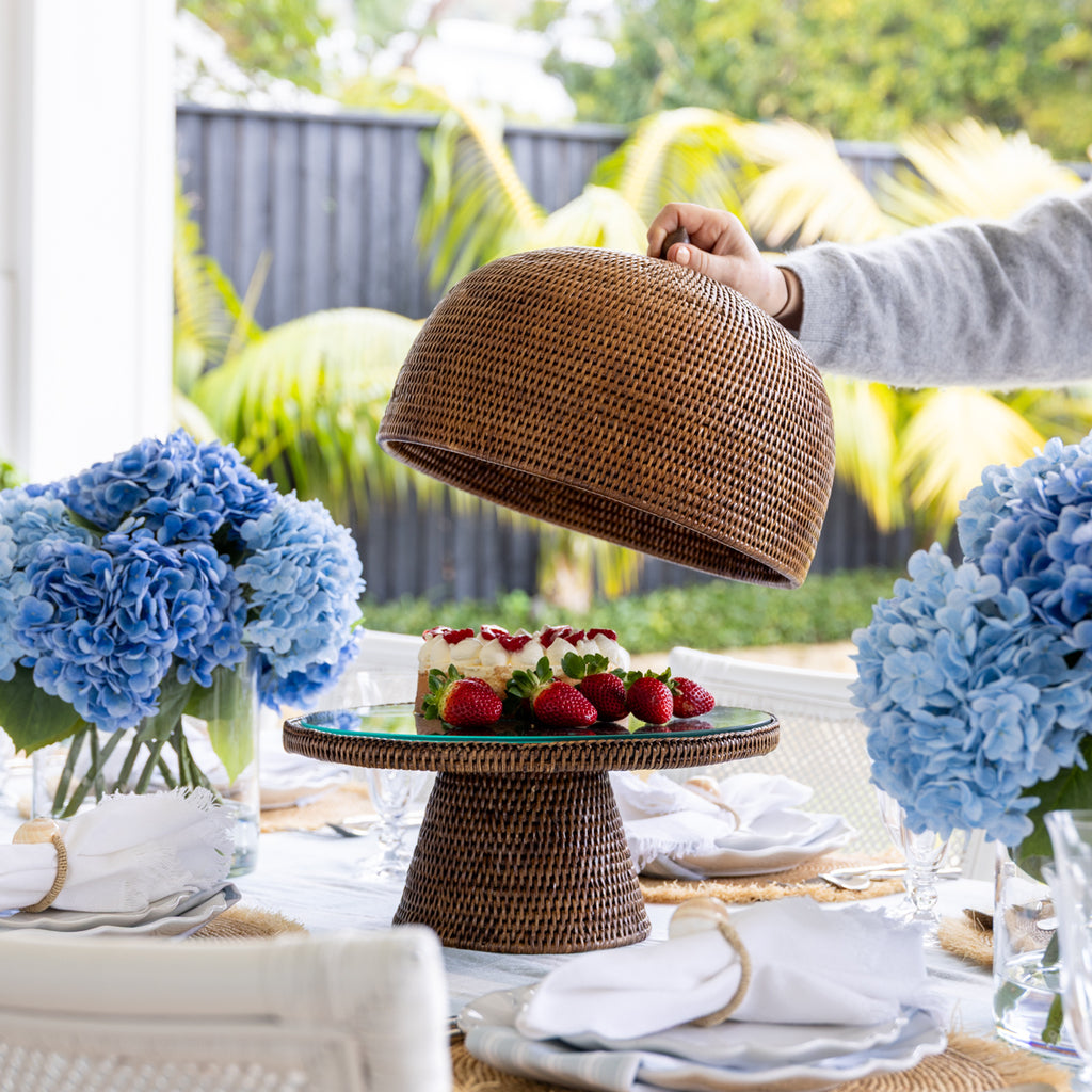 Rattan Food Cloche Dome Brown Styled on Dining Table with Cake Stand and Cake