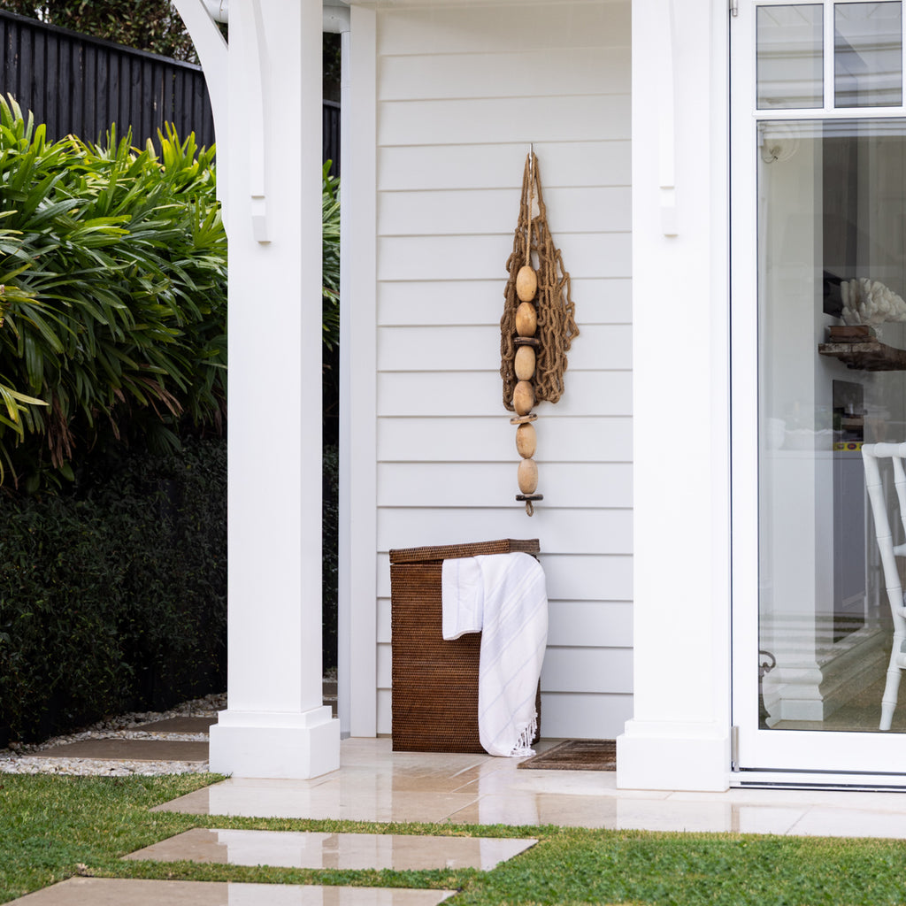 Rattan London Laundry Hamper Brown Styled Outside with Towel