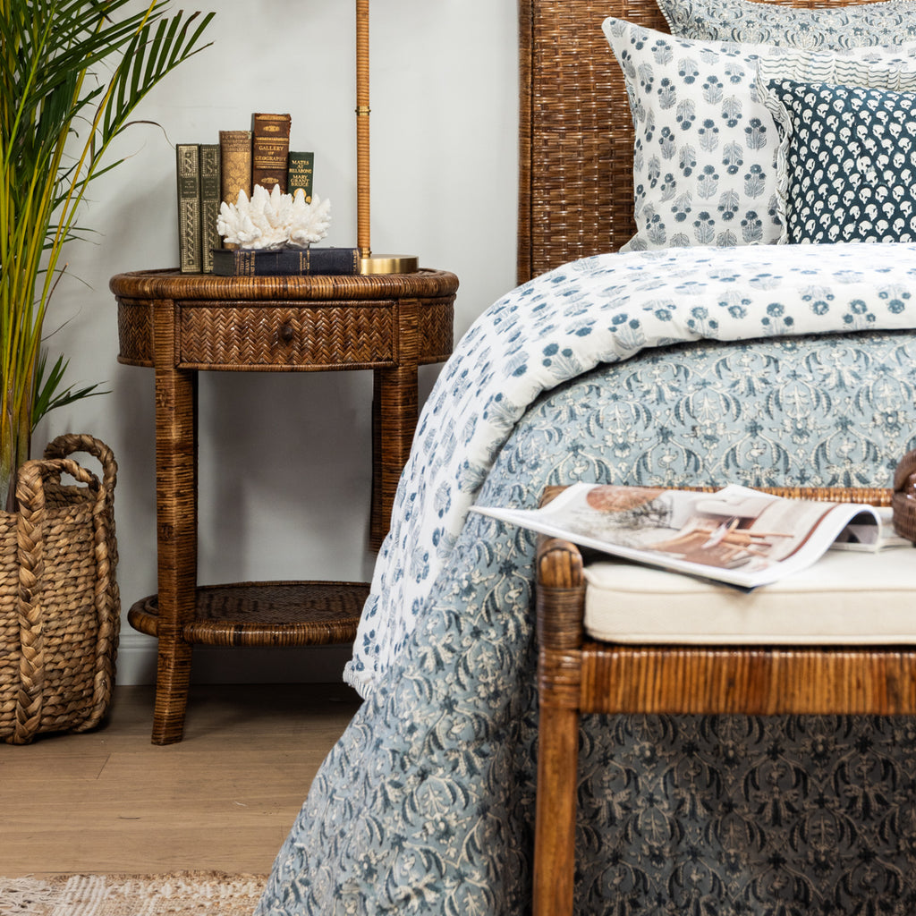 Rattan Round Side Table (Brown) Styled next to Bed with Coral and Books on Table