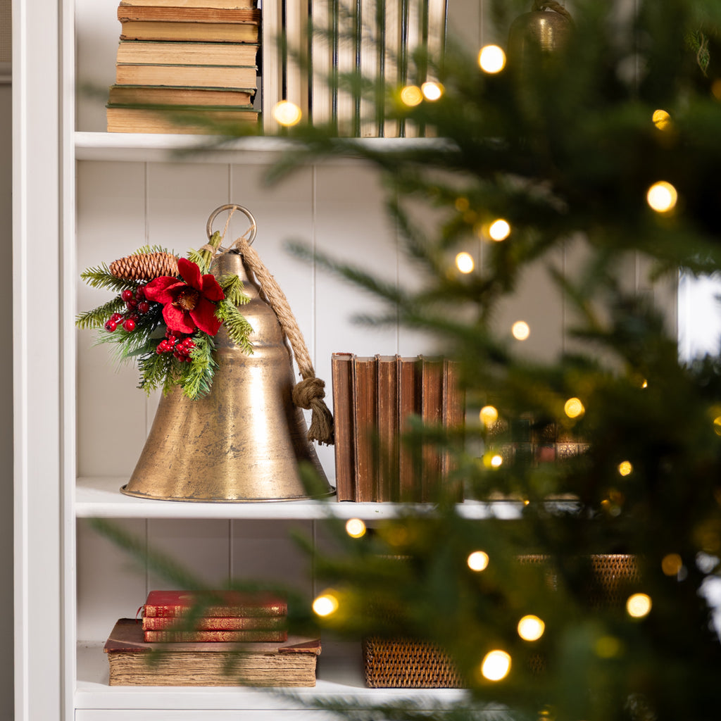Red Magnolia Posy 30cm Styled on Bell on Bookcase with Christmas Tree in Foreground