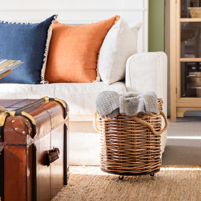 Round Willow Baskets Styled Next to Sofa with Blanket Inside