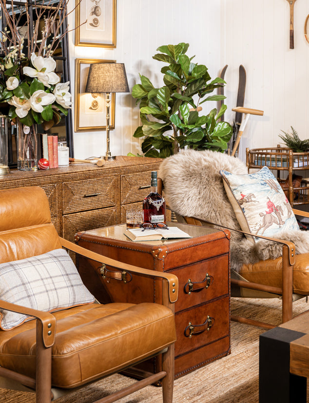 Heritage living room with leather armchair, wooden side table, and decorative sporting pieces.