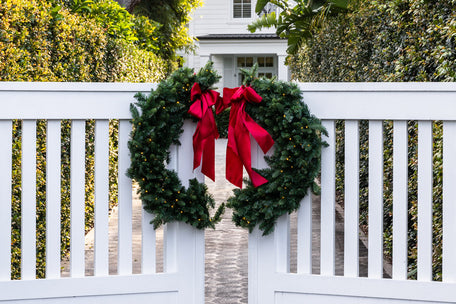 Christmas split wreath on white gates.