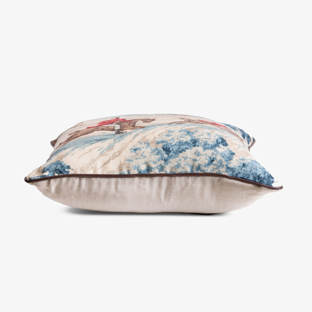 Decorative pillow with an illustration of people hunting on horseback. 