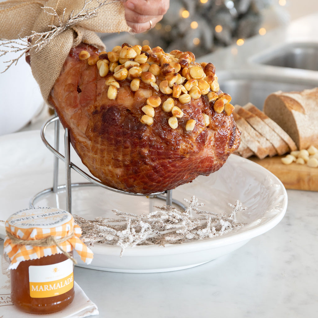 A ham sitting on the metal ham stand ready for carving.
