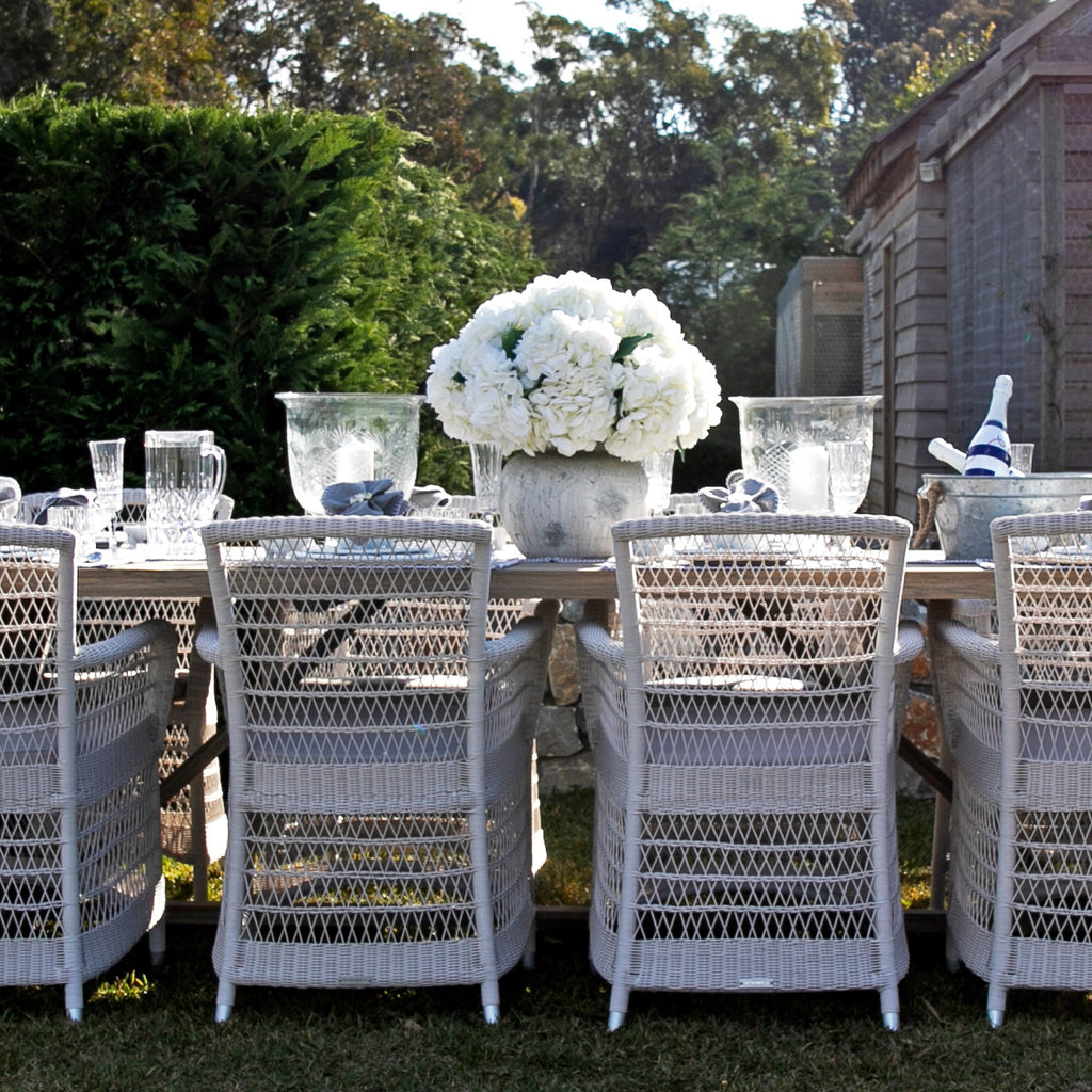 Hampton Outdoor Dining Chairs in white in a garden with white Hydrangeas on a table