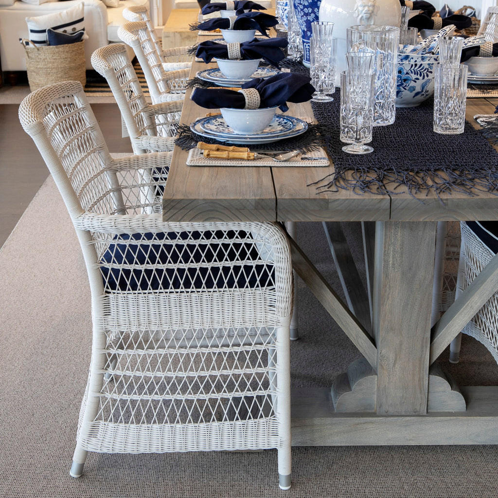 Hampton Outdoor Dining Chairs in white around a wooden dining table 