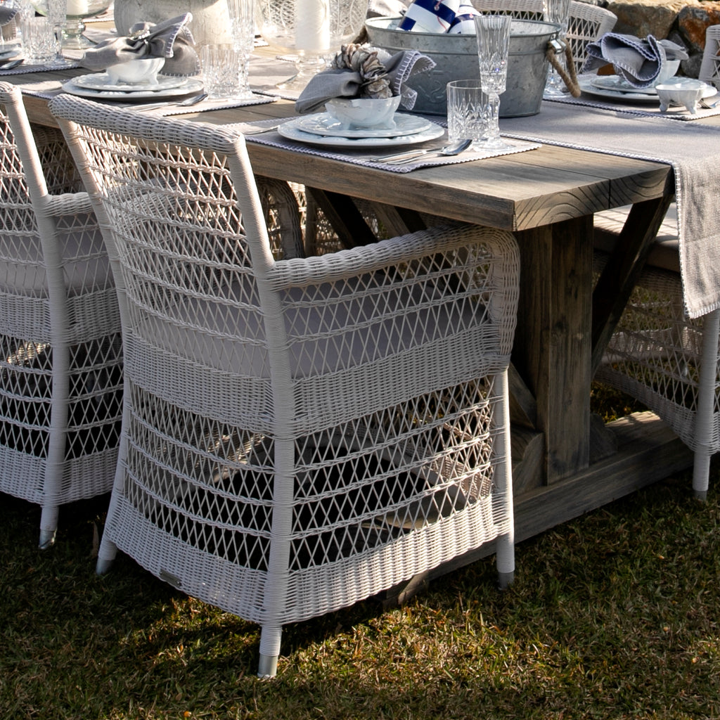 Hampton Outdoor Dining Chairs in white at rectangle wooden table in a garden